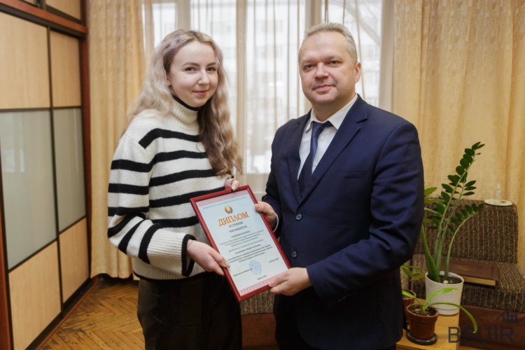 Проректор БГУИР по воспитательной работе Дмитрий Кузнецов вручает диплом студентке Илоне Габриневской